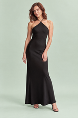 Vestido largo negro con detalle retorcido, cuello halter y capa