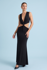 Vestido largo negro de escote asimétrico, con aberturas en la cintura y detalles dorados