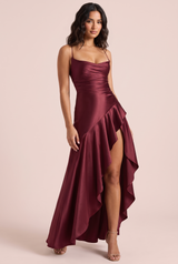 Vestido largo burdeos satinado con espalda de cordones y falda asimétrica con volantes